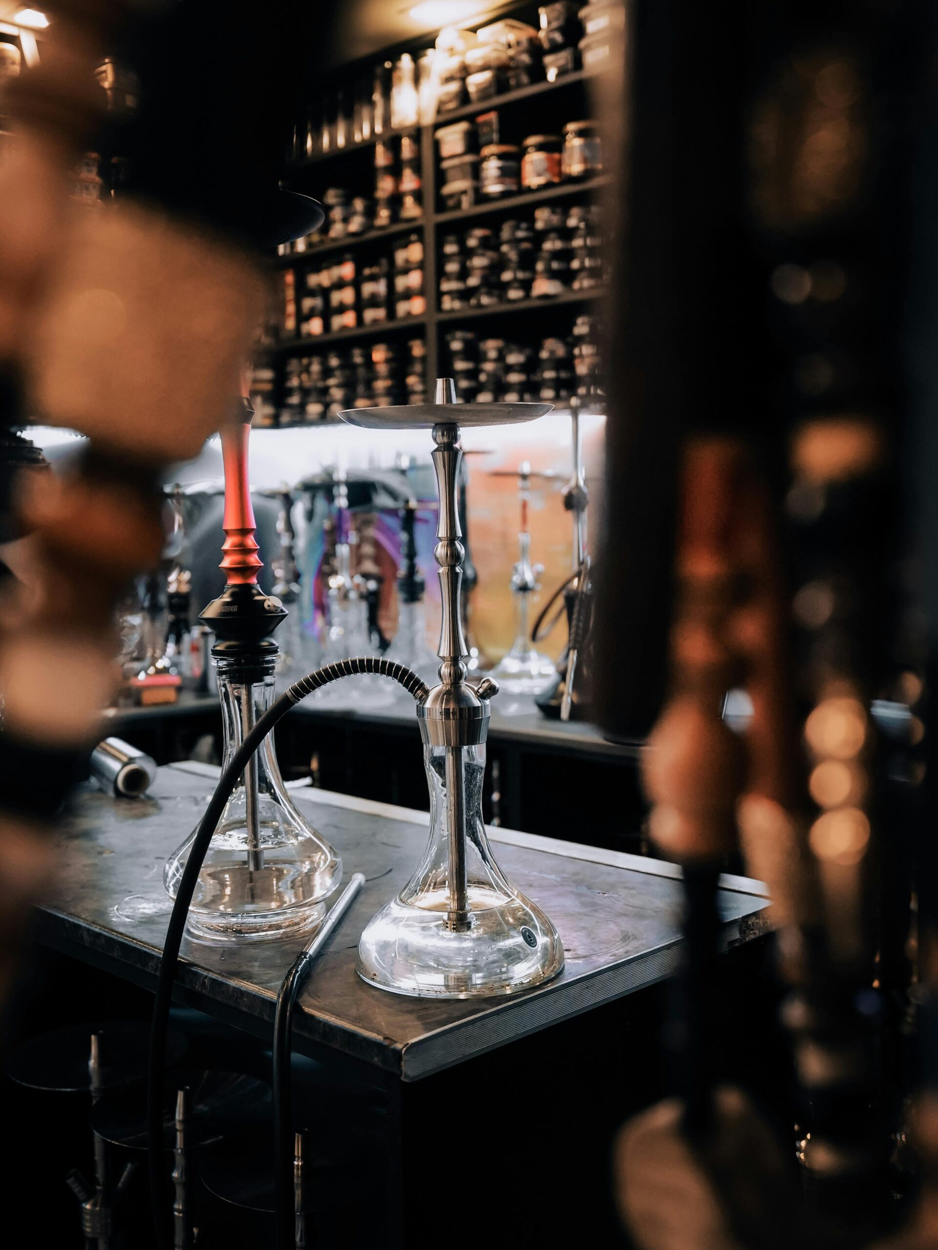 Cozy hookah lounge featuring various hookah pipes on display.